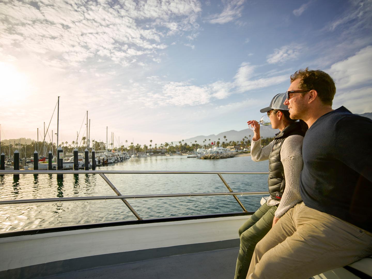 a man sitting on a dock next to a body of water