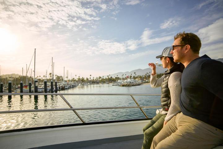 a man sitting on a dock next to a body of water