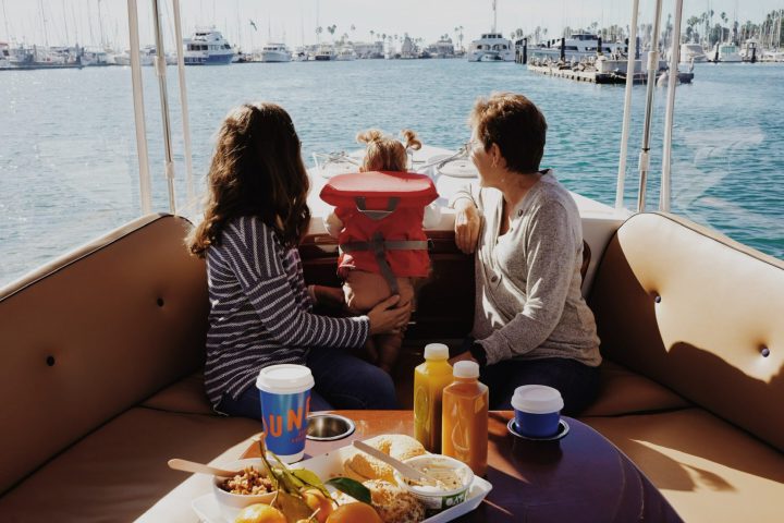 a woman sitting at a table in front of a body of water